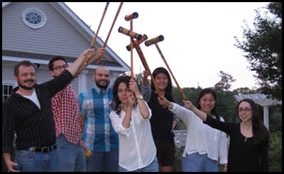 Members of the Gerbi Lab holding up croquet mallets at the annual picnic.