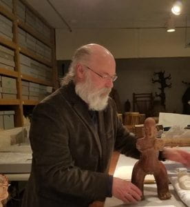 man holding a clay figure on a table