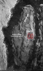 high elevation black and white aerial photo of island showing ruins, marked 
