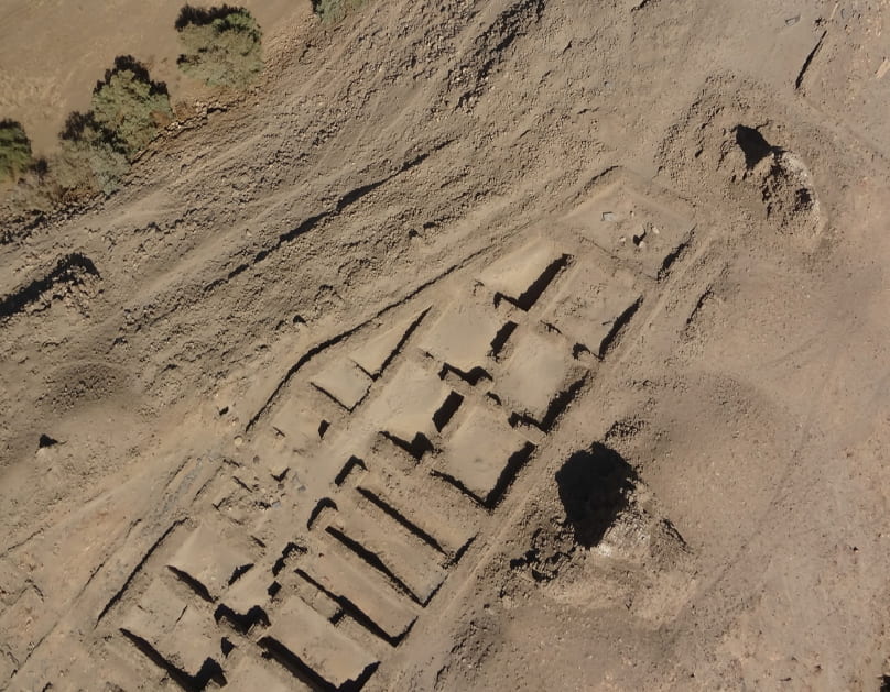 aerial photograph of mudbrick ruins showing square rooms with thick walls